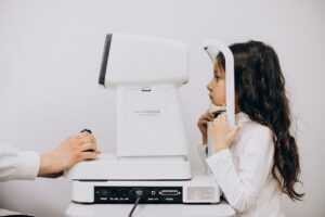 Badanie optometryczne przeprowadzane u małej dziewczynki w salonie optycznym.